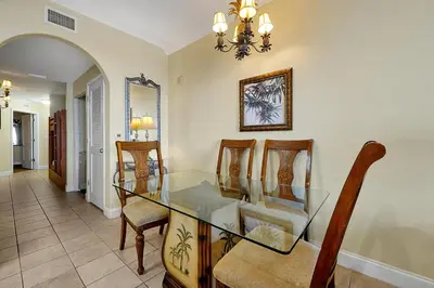 a dining room with a glass table and chairs at Disney Dream Condo & Lake View Awaits! in Orlando