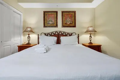 a bedroom with a large white bed with two lamps at Disney Dream Condo & Lake View Awaits! in Orlando