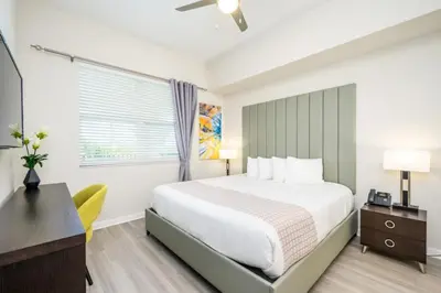 a bedroom with a bed and a desk and a window at Epic Universe New Modern Vista Cay Reserve Condo - 5005 in Orlando