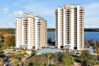 two tall white buildings next to a body of water at Living the Disney Dream! Lake View Luxury Condo in Orlando
