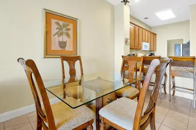 a dining room with a glass table and chairs at Living the Disney Dream! Lake View Luxury Condo in Orlando