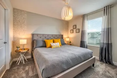a bedroom with a bed with yellow pillows and a window at 6Q/6B | Piscina Privativa | Game Room Temático in Kissimmee