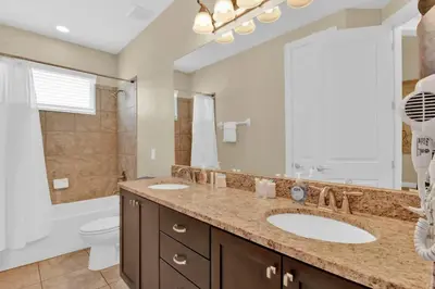 a bathroom with two sinks and a large mirror at Relaxing 6BR Home w Pool Near Disney in Orlando