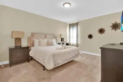 a bedroom with a large white bed and a window at Relaxing 6BR Home w Pool Near Disney in Orlando