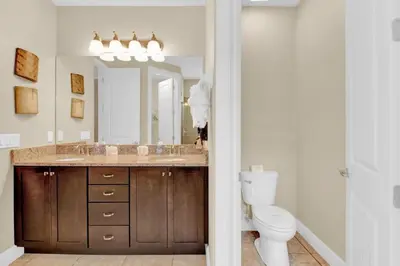 a bathroom with a sink and a toilet and a mirror at Relaxing 6BR Home w Pool Near Disney in Orlando