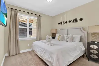 a bedroom with a white bed and a window at Relaxing 6BR Home w Pool Near Disney in Orlando