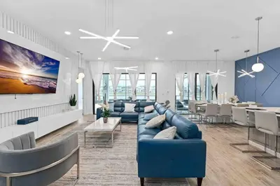 a living room with a blue couch and a table at SUPER RITZY - 9BDRs-9BAs w Theme Rooms LOFT & POOL in Orlando