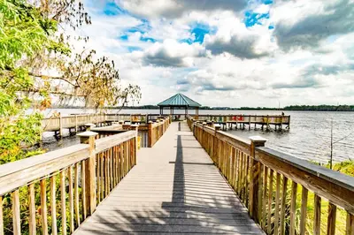 a wooden dock on a lake with a gazebo at Orlando 12th Floor - 5 min Disney in Orlando