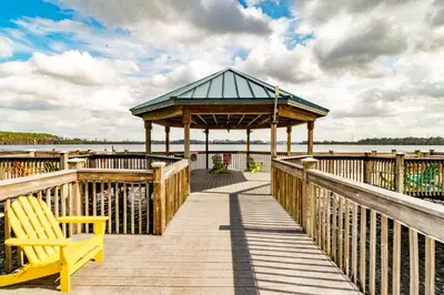 a wooden boardwalk with a gazebo and a yellow bench at Orlando Blue Heron 1 Mile From Disney 2nd floor in Orlando