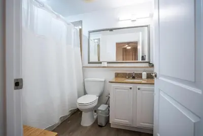 a white bathroom with a toilet and a mirror at Orlando Blue Heron 1 Mile From Disney 2nd floor in Orlando