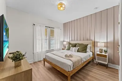 a bedroom with a large bed and a television at SUPER BOHO - LAKE TOHO FISHiNG WATER FRONTs in Kissimmee