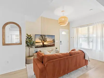 a living room with a brown leather couch at SUPER BOHO- At LAKE TOHO's WATER SLEEPs 6 in Kissimmee