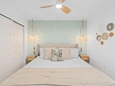 a white bedroom with a large bed with pillows at SUPER BOHO- At LAKE TOHO's WATER SLEEPs 6 in Kissimmee