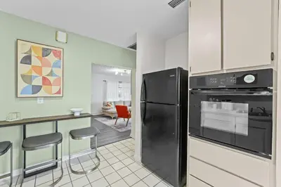 a kitchen with a black refrigerator and a counter at SUPER BOHO - At Lake Toho Fishing VINTaGE VIBEs in Kissimmee