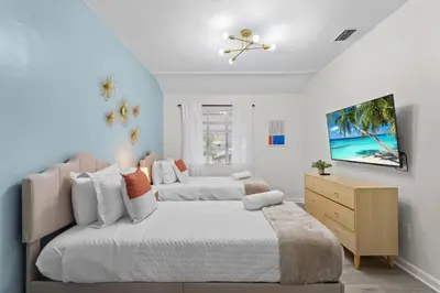 a bedroom with two beds and a dresser at SUPER BOHO - At Lake Toho Fishing VINTaGE VIBEs in Kissimmee