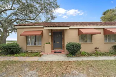 a house with a blue door and a tree at SUPER BOHO - At Lake Toho Fishing VINTaGE VIBEs in Kissimmee