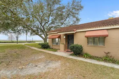 a house with a tree and a driveway at SUPER BOHO - At Lake Toho Fishing VINTaGE VIBEs in Kissimmee