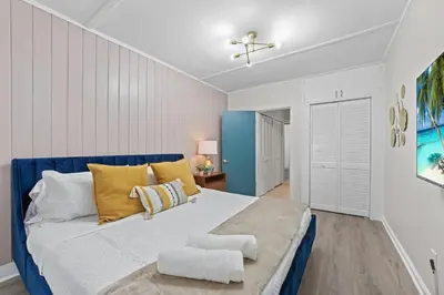 a bedroom with a large bed with yellow and blue pillows at SUPER BOHO - Lake Toho Timeless Charm in Kissimmee