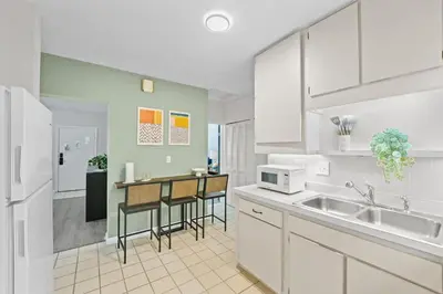 a kitchen with white cabinets and a counter top at SUPER BOHO - Lake Toho Timeless Charm in Kissimmee