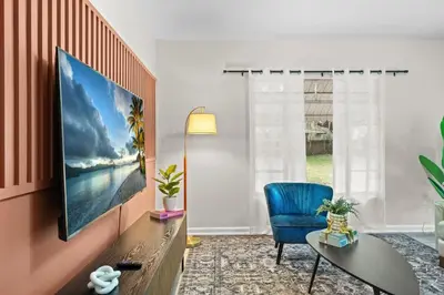 a living room with a blue chair and a television at SUPER BOHO - Lake Toho Timeless Charm in Kissimmee