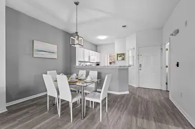 a dining room with a table and white chairs at SUPER YES - MANY AMENITIEs RELAX GYM COURTs in Kissimmee