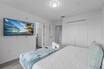a bedroom with a large bed with a painting on the wall at SUPER YES - MANY AMENITIEs RELAX GYM COURTs in Kissimmee