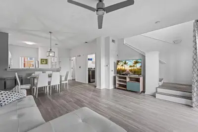 a living room with a ceiling fan and a dining room and kitchen at SUPER YES - MANY AMENITIEs RELAX GYM COURTs in Kissimmee