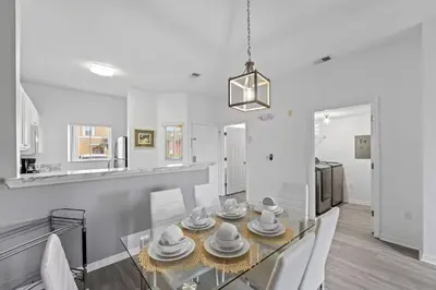a dining room with a glass table with dishes on it at SUPER YES - MANY AMENITIEs RELAX GYM COURTs in Kissimmee