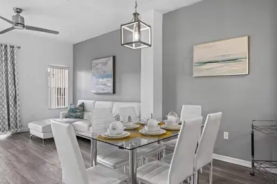 a living room with a dining table and a couch at SUPER YES - MANY AMENITIEs RELAX GYM COURTs in Kissimmee