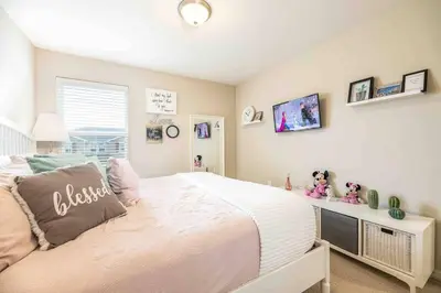 a bedroom with a large bed and a desk at SUPER CHIC - 4 Bedroom TOWNHOME IN DISNEY AREA in Kissimmee