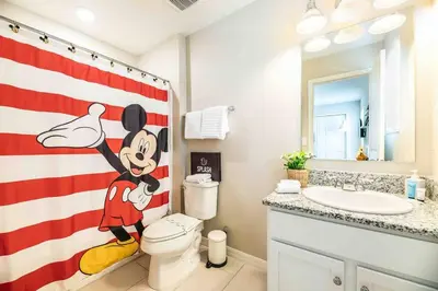 a bathroom with a toilet and an american flag shower curtain at SUPER CHIC - 4 Bedroom TOWNHOME IN DISNEY AREA in Kissimmee