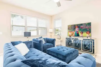 a living room with a blue couch and two chairs at SUPER CHIC - 4 Bedroom TOWNHOME IN DISNEY AREA in Kissimmee
