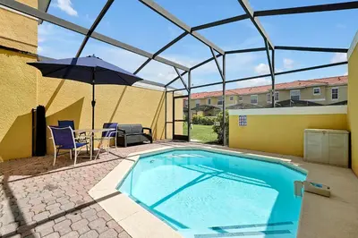 a swimming pool with an umbrella and a table and chairs at Encantada Resort - Spacious 3-Bedroom Villa with Private Pool Near Disney in Kissimmee