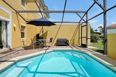 a swimming pool with an umbrella and a table and chairs at Encantada Resort - Spacious 3-Bedroom Villa with Private Pool Near Disney in Kissimmee