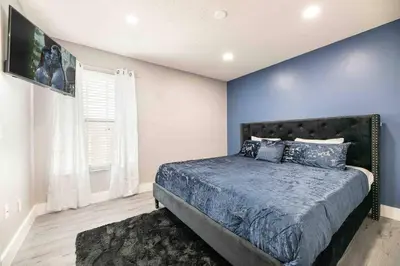 a bedroom with a bed with a blue wall at SUPER GLAM - GAME ROOM and POOL in Orlando