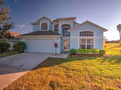 a large white house with a driveway at SUPER GLAM - GAME ROOM and POOL in Orlando