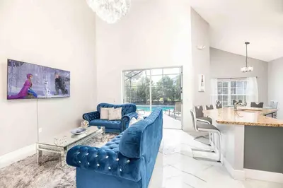 a living room with two blue chairs and a table at SUPER GLAM - GAME ROOM and POOL in Orlando