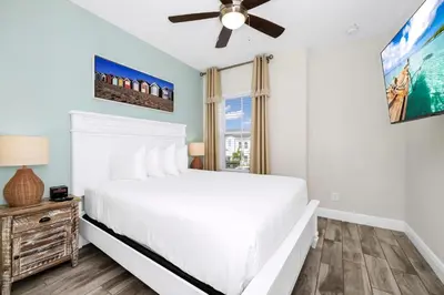 a bedroom with a white bed and a ceiling fan at Sky Blue Villa Near Disney With Margaritaville Resort & Island H20 Waterpark Access - 3156Cs in Orlando