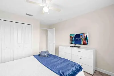 a bedroom with a bed and a ceiling fan at SUPER DOPE- Home w POOL & AMENITIEs in Kissimmee