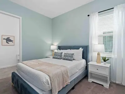 a blue bedroom with a bed and a window at SUPER JUMBO - 12BD 12BAs SLEEPs 34 - w AMENITIEs in Kissimmee