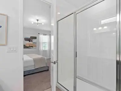 a bathroom with a glass door leading to a bedroom at SUPER JUMBO - 12BD 12BAs SLEEPs 34 - w AMENITIEs in Kissimmee