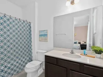 a bathroom with a toilet and a sink and a mirror at SUPER JUMBO - 12BD 12BAs SLEEPs 34 - w AMENITIEs in Kissimmee