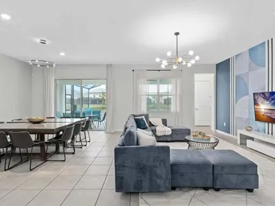 a living room with a couch and a dining room at Super Huge- 12BD 12BAs - Sleeps 38 in Kissimmee