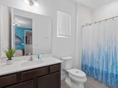 a bathroom with a toilet and a sink and a shower at SUPER SPACE - 12BD 12BA - MANY ENSUITEs SLEEPs 38 in Kissimmee
