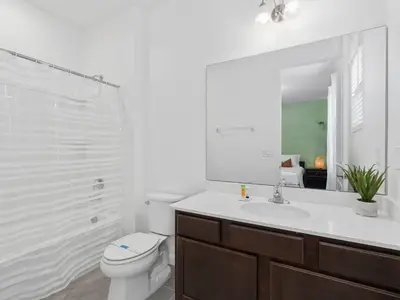 a bathroom with a toilet and a sink and a mirror at SUPER SPACE - 12BD 12BA - MANY ENSUITEs SLEEPs 38 in Kissimmee
