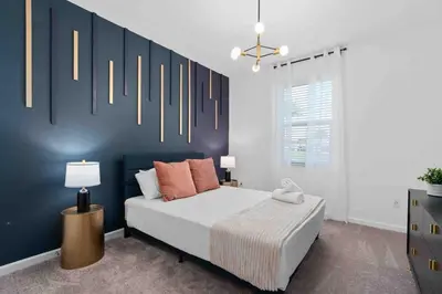 a bedroom with a bed and a blue wall at SUPER FANCY- 15BDR 17BAs HUGE 7 000SQFT HOME in Kissimmee
