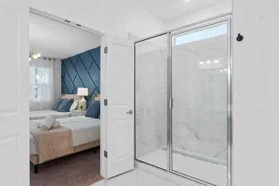 a bedroom with a glass walk in shower next to a bed at SUPER FANCY- 15BDR 17BAs HUGE 7 000SQFT HOME in Kissimmee
