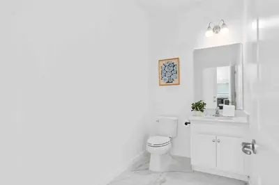 a white bathroom with a toilet and a sink at SUPER FANCY- 15BDR 17BAs HUGE 7 000SQFT HOME in Kissimmee