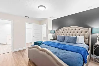 a bedroom with a large bed with a blue blanket at SUPER EPIC- SLEEPs 32 TWO Separate Townhomes in Kissimmee