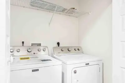 a kitchen with two white appliances and a window at SUPER EPIC- SLEEPs 32 TWO Separate Townhomes in Kissimmee